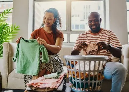 a-young-husband-and-wife-folding-their-laundry-happily-stock-photo