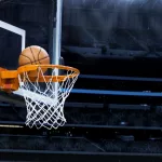 Large basketball arena; closeup of basketball going into hoop