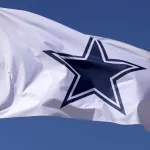 Dallas Cowboys flag flies in front of the AT&T Stadium located in Arlington^ Texas