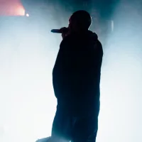 Silhouette of a singer/rapper with a towel. Bright background.