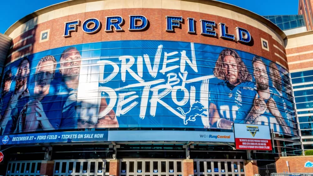 Closeup of "Ford Field" Detroit Lions' football field stadium's exterior facade brand and logo signage on a sunny day.