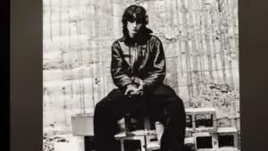 An Apple iPad displays the Spotify music streaming app. The screen the shows the song "undressed" by "Sombr" being played^ as well as the album cover art.