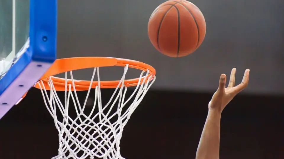 Orange basketball ball flying into the basketball hoop