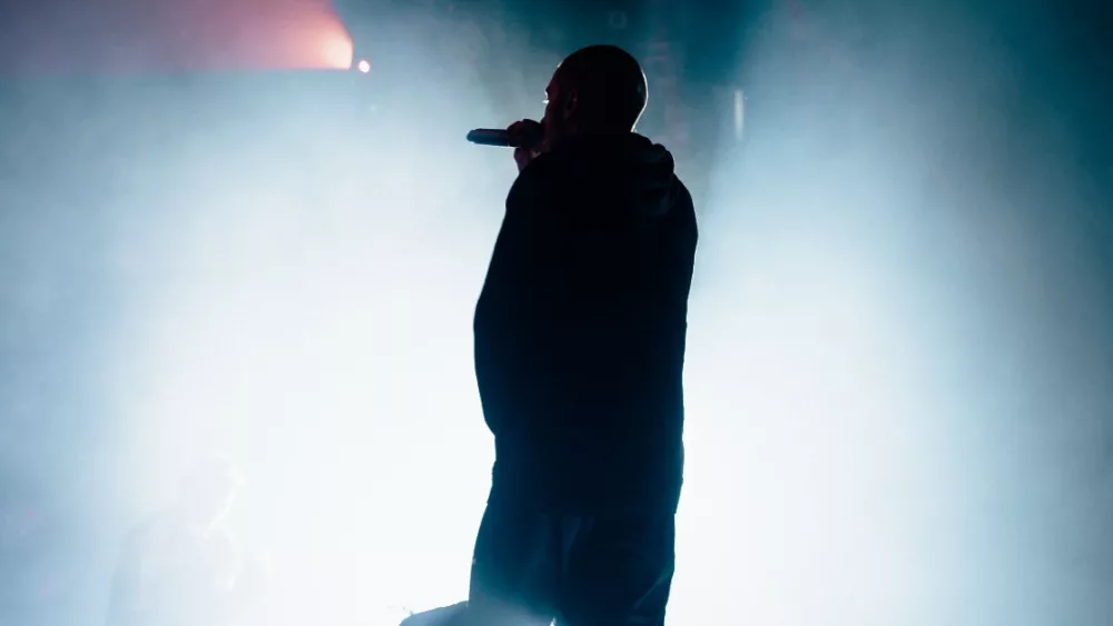 Silhouette of a singer/rapper with a towel. Bright background.