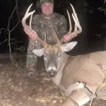 Trevor Alexander: I decided to sit in a new stand for the first time since it was put up. Was not expecting to see much. There is a small pond next to the stand at around 6pm a couple small bucks came into the pond at 30 yards. They were watching intently behind them. Suddenly there was some small trees moving violently in the distance. I looked through my binoculars and saw this buck that we had several pictures of. He came to the pond and presented a perfect 30 yard shot. He only went about 70 yards and fell. This is my biggest buck I have harvested with a bow yet.