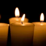 Soft focus of white candles burning^ isolated on black background. Concept of religion^ death^ memoriam^ and peace