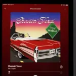 An Apple iPad displays the Spotify music streaming application^ which is playing the song "Choosin' Texas" by the artist Ella Langley