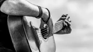Acoustic guitars playing. Music concept. Black and white. Male musician playing guitar^ music instrument. Man's hands playing acoustic guitar^ close up.