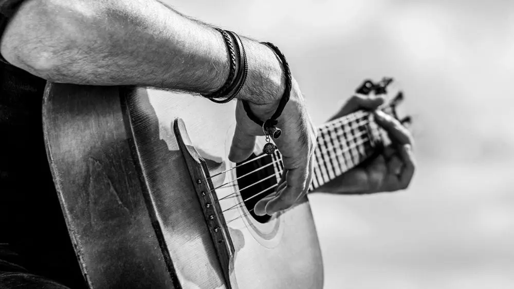 Acoustic guitars playing. Music concept. Black and white. Male musician playing guitar^ music instrument. Man's hands playing acoustic guitar^ close up.