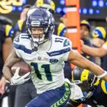 Seattle Seahawks wide receiver Jaxon Smith-Njigba (11) escapes a tackle-attempt by Los Angeles Rams cornerback Emmanuel Forbes Jr. (1) during an NFL football game Nov. 16^ 2025^ in Inglewood^ Calif.