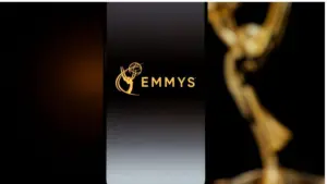 Emmys logo displayed on a smartphone screen with a blurred gold award statuette in the background^ television industry awards and digital streaming concept. Kaunas^ Lithuania - 2026 March 24