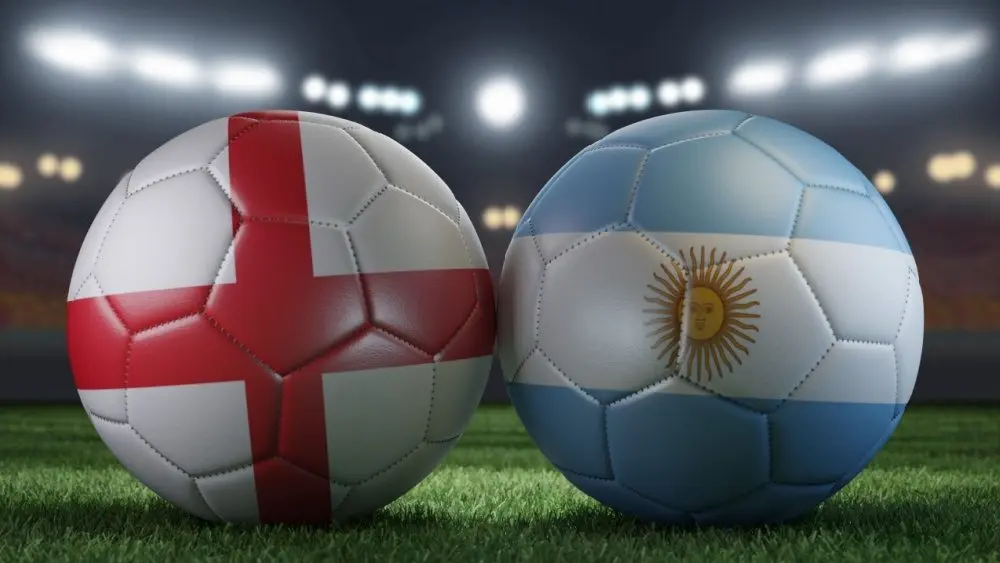 Two soccer balls in flags colors on a stadium blurred background. England vs Argentina. 3D image.