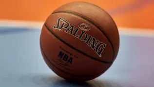 Gdansk^ Poland - 08 02 2024: Close-up of a Spalding NBA basketball resting on a blue and orange court^ focusing on the texture of the ball and the surrounding vibrant colors of the court.