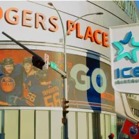Edmonton Oilers hockey team fans waving flags outside Rogers Place stadium^ with Oilers hockey players pictured on the LED billboard. Edmonton^ Alberta^ Canada