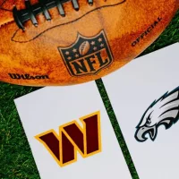 Washington Commanders vs Philadelphia Eagles. NFC Championship Game in NFL 2025. Playoff game. American football Ball on green Grass.