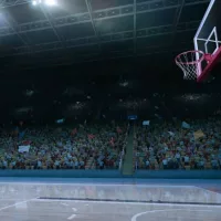empty basketball court; shot of hoop and crowd in background