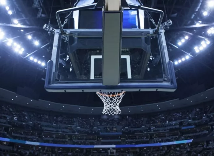 Brightly lit Basketball backboard in a large sports arena.