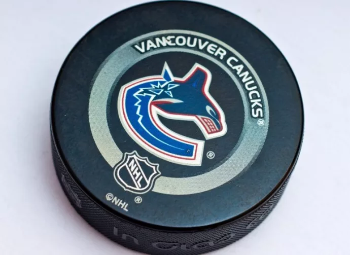 Official Vancouver Canucks game puck on the ice ^product shot