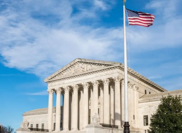 Facade of the United States Suprement Court with American flag in Washington^ DC