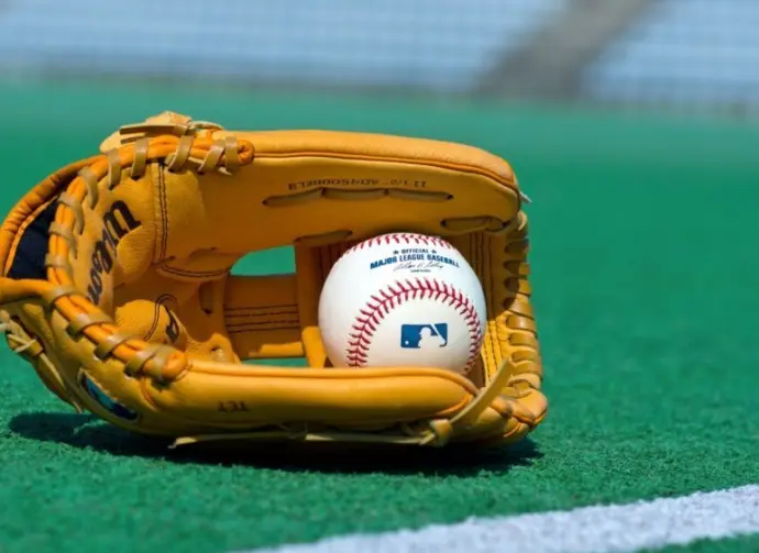 Official Major League Baseball ball and glove on the green field ^ product shot