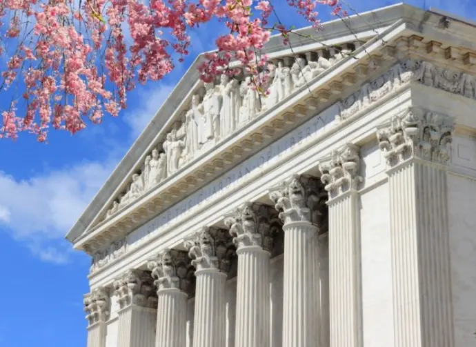 Washington D.C. US Supreme Court building. during spring time; cherry blossoms seen in front of image of Supreme Court