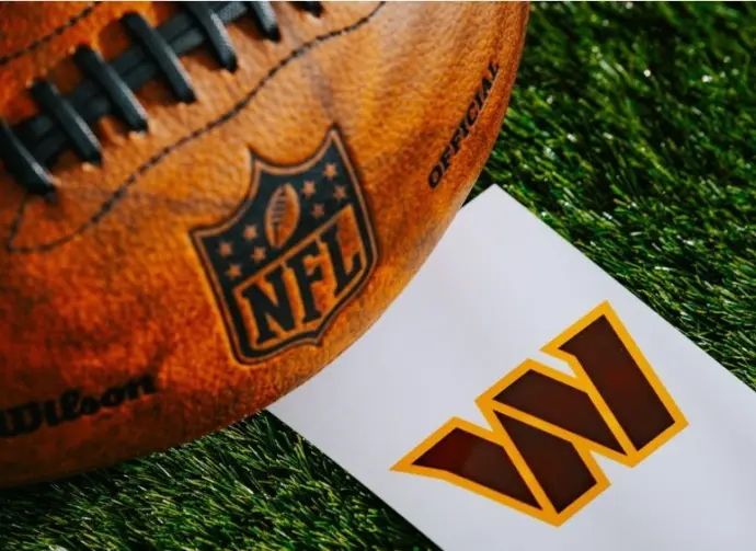 Washington Commanders NFL team Logo and American football ball on Green Grass.