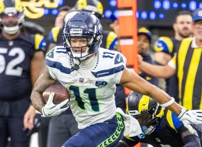 Seattle Seahawks wide receiver Jaxon Smith-Njigba (11) escapes a tackle-attempt by Los Angeles Rams cornerback Emmanuel Forbes Jr. (1) during an NFL football game Nov. 16^ 2025^ in Inglewood^ Calif.