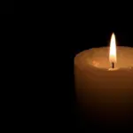 One big burning candles. Bright light on black background. RIP darkness template. Romantic evening on Valentine.