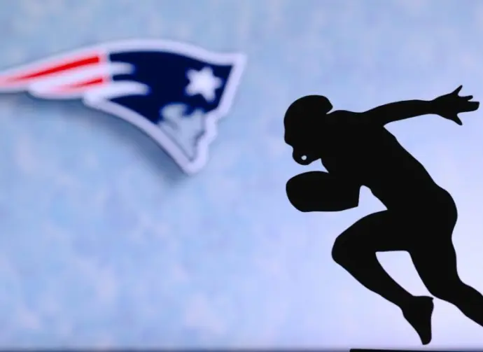 New England Patriots. Silhouette of professional american football player. Logo of NFL club in background^ edit space.