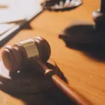 law books and scales of justice on desk in library of law firm. jurisprudence legal education concept.