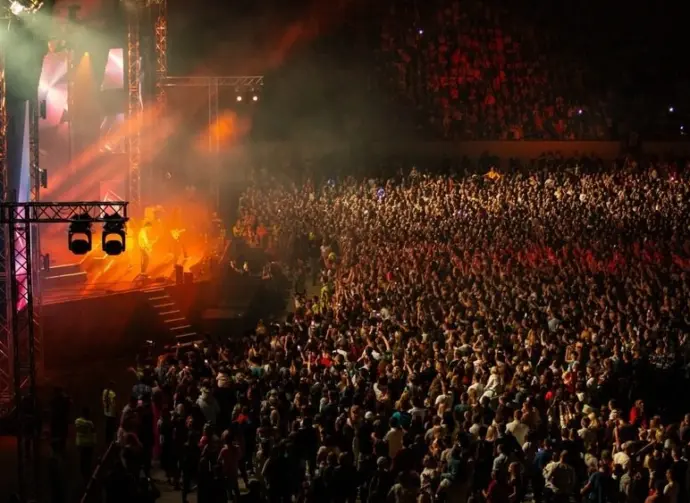 Large Concert Crowd and Stage Lighting in a Stadium at Night
