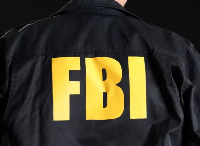 Mature FBI agent on black background^ back view