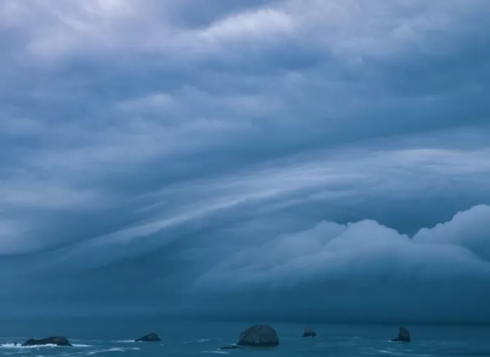 Storm clouds from bomb cyclone over sea stacks in the ocean at the Oregon Coast.