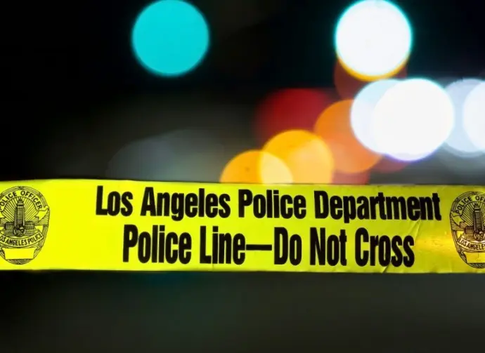 Police barricade tape with the writing 'LOS ANGELES POLICE DEPARTMENT POLICE LINE - DO NOT CROSS' illuminated night exterior with deliberately blurred background Los Angeles - January 2^ 2021