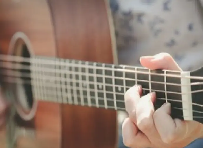 close of of hand playing guitar