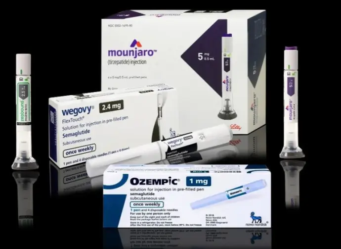 Injection pens and packaging boxes of weight-loss and type 2 diabetes medication Mounjaro^ Wegovy^ Ozempic^ Zepbound Isolated on black background with reflections.