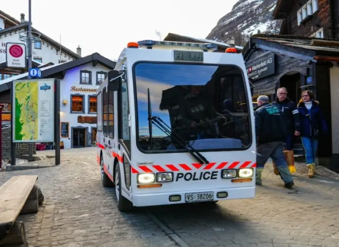 Zermatt^ Switzerland - Feb 19^ 2024 : Police vehicle in the city center of the ski resort of Zermatt in the Canton of Valais^ Switzerland - Narrow electric car Jumbolino in a car-free town of the Swis