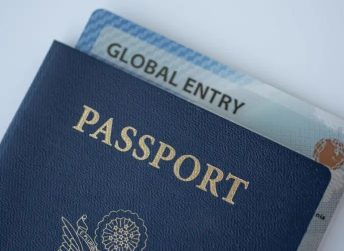 Global Entry card (Trusted traveller) covered of Passport of United states on white background.
