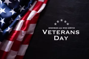 happy-veterans-day-american-flags-veterans-against-a-blackboard