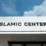 Islamic Center sign on a community building under blue sky^ symbolizing worship^ cultural education^ Muslim community services^ faith^ and spiritual guidance