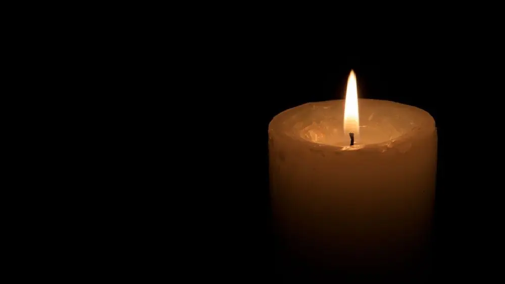 One big burning candles. Bright light on black background. RIP darkness template. Romantic evening on Valentine.