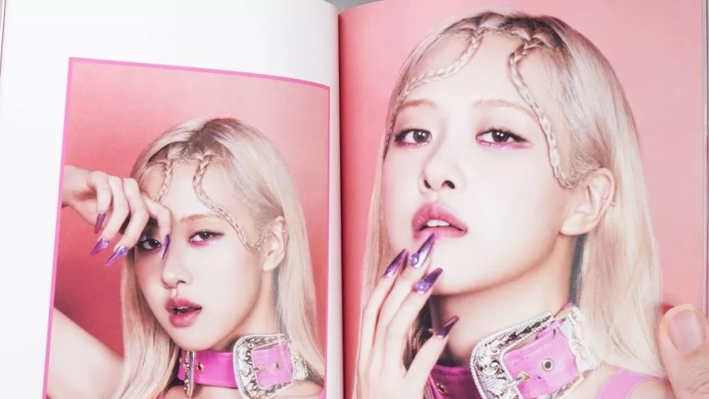 Fan hands holding BlackPink BORN PINK 2nd Album photobook with Rose on grey. Pink music CD in player. South Korean girl group BlackPink. Space for text. Gatineau^ QC Canada - November 10 2022.