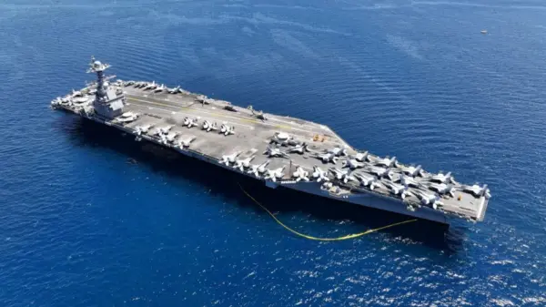Aerial drone photo of USS Gerald R. Ford latest technology nuclear powered aircraft carrier anchored in deep blue open ocean sea