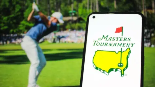 Masters Tournament logo displayed on a mobile phone with a photo of a player taking a swing on its website in the background^ the world's premier golf championship. Indonesia - May 15^ 2025