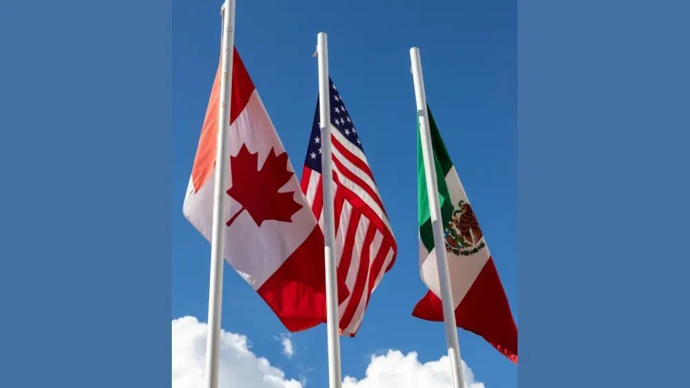 Flags of United States^ Mexico^ Canada flying together^ concept of new NAFTA agreement now known as USMCA in the U.S.^ CUSMA in Canada or T-MEC in Mexico.