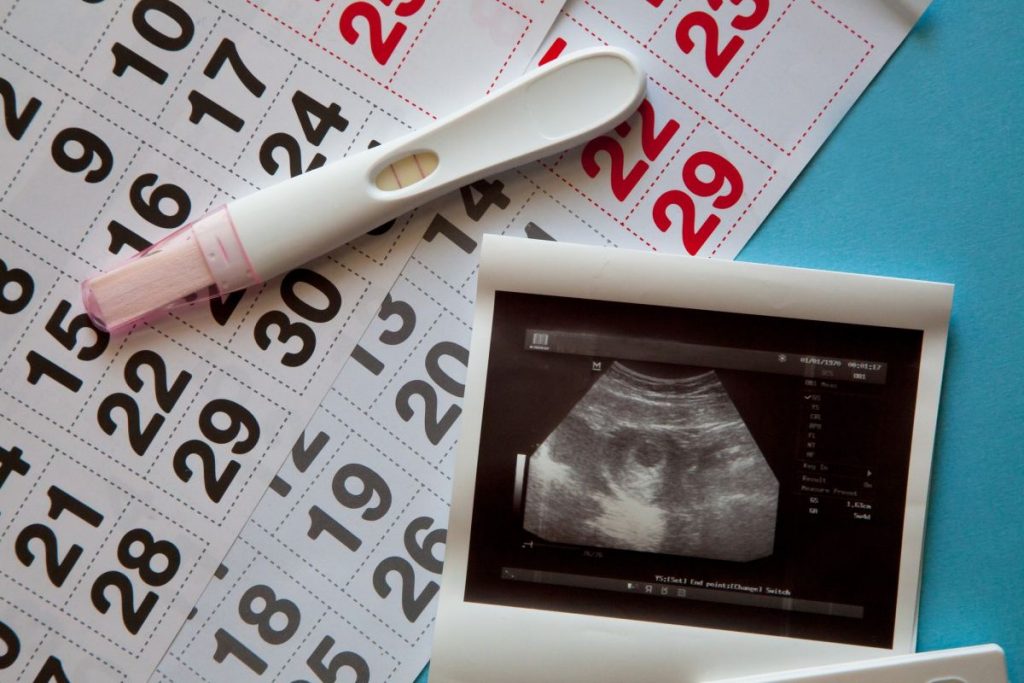 ultrasound-scan-of-an-unborn-baby-of-fifth-week-with-a-pregnancy-test-and-calendar-on-the-blue-1024x683-1