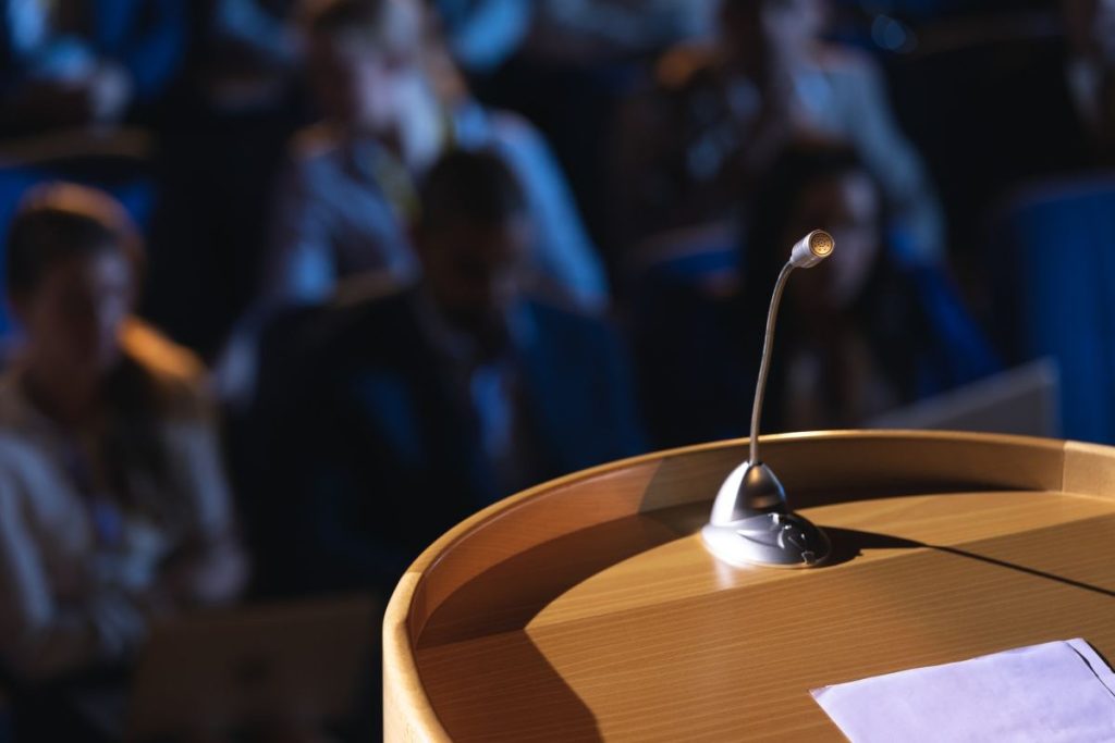 close-up-of-podium-with-speaker-in-auditorium-1024x683-1