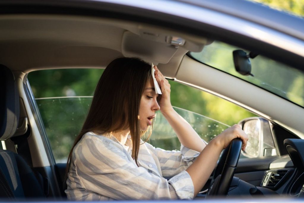 woman-driver-being-hot-during-heat-wave-in-car-suffering-from-hot-weather-wipes-sweat-from-forehead-1024x683-1