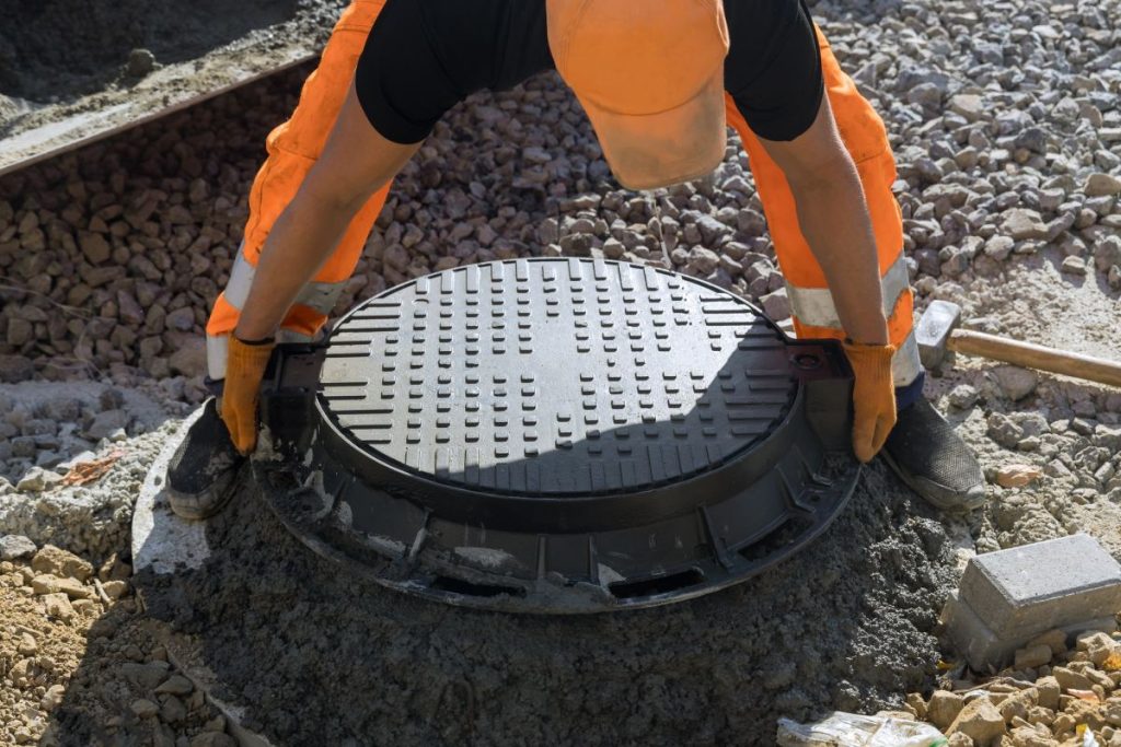 installing-cast-iron-sewer-hatch-on-a-concrete-base-of-installation-of-water-main-sewer-well-in-the-1024x683-1