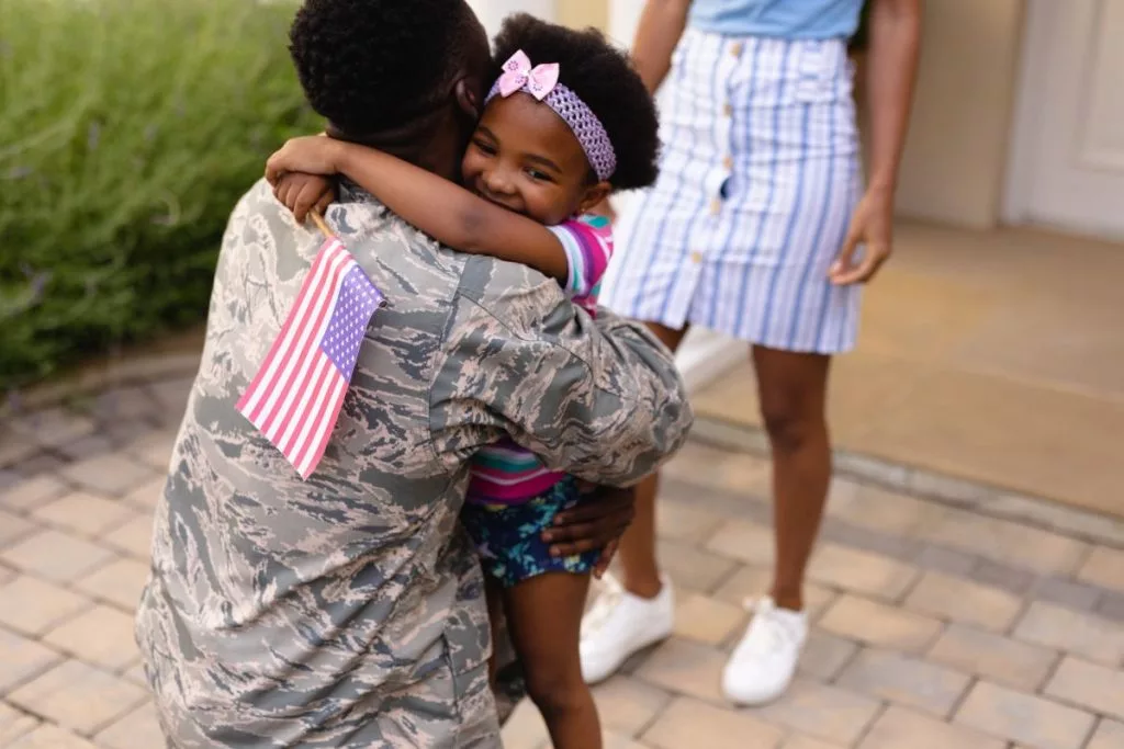 army-soldier-embracing-african-american-girl-with-usa-flag-at-house-entrance-1024x683443283-1